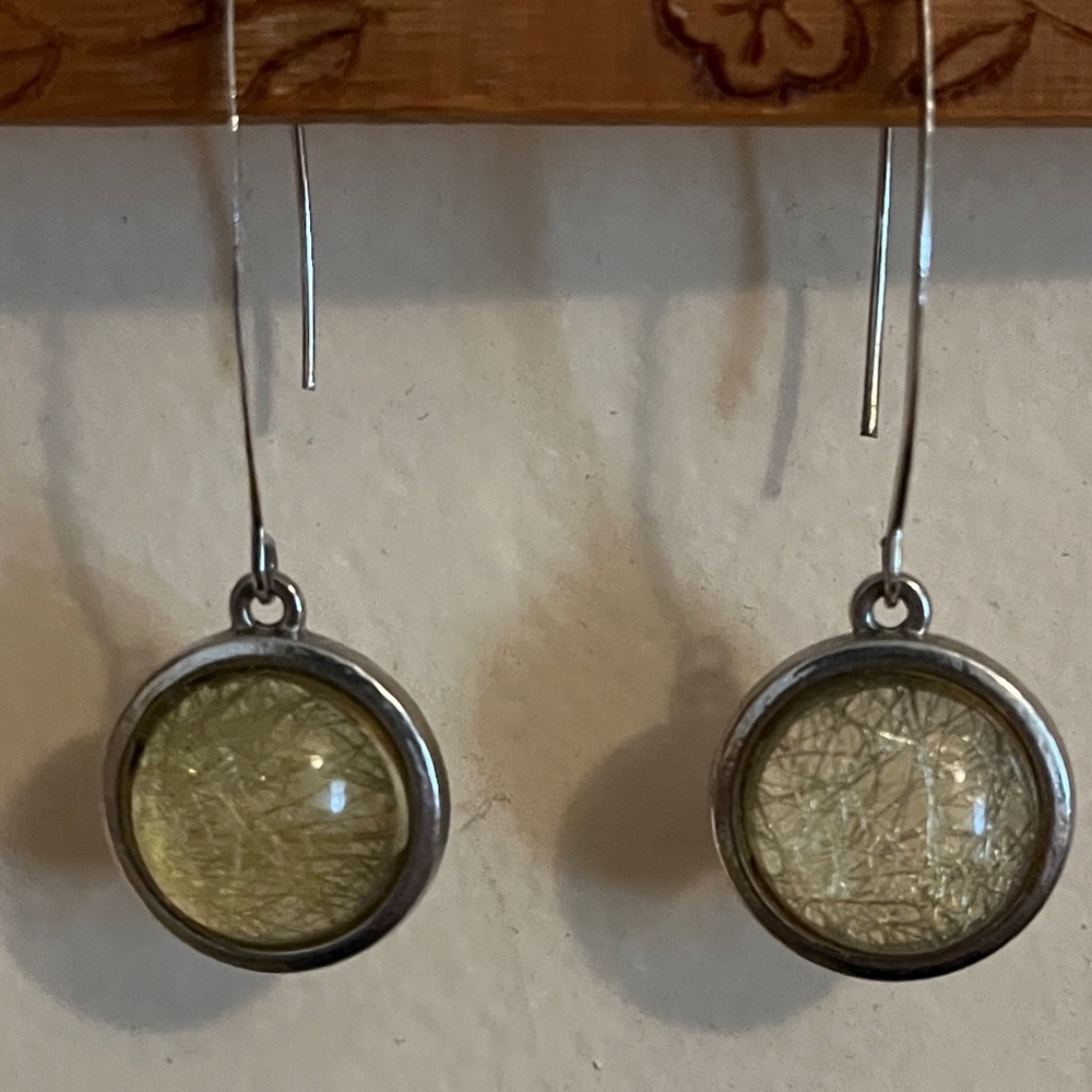 Silver drop earrings with a variation of greenish yellow round stones